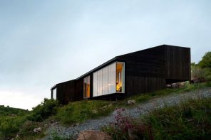 Experience the Norwegian sloped hills in this minimal blackwood cabin!