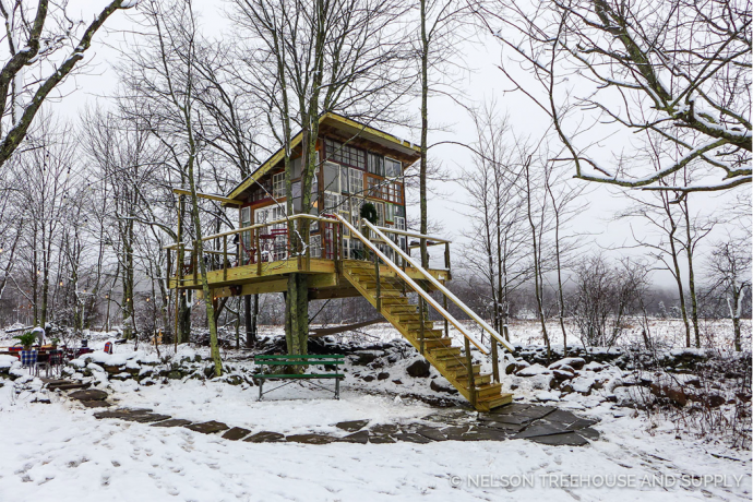 Recycled windowpanes make up the walls of this treehouse for 360 views of the snowy Catskills!