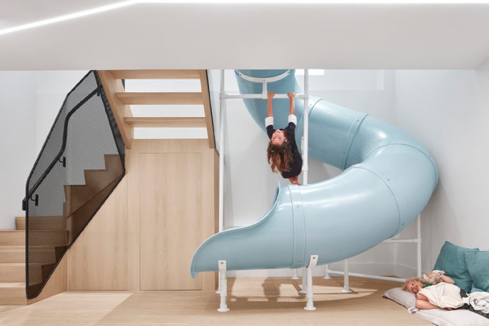 A giant blue slide sits in the middle of this modern family home!