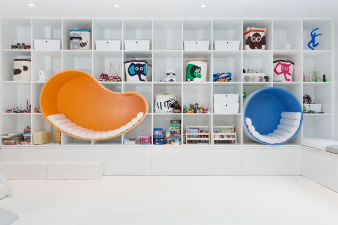 The bookshelf integrating seating nooks makes this renovated basement the ideal summer escape!