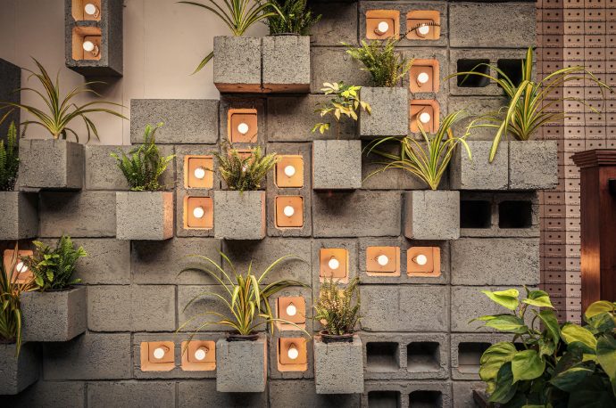 This concrete restaurant merges brutalist architecture with a vertical garden design for an inviting green vibe!