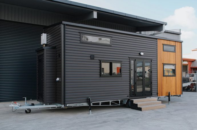 This tiny home features an open-plan layout and solar system for off-grid living!