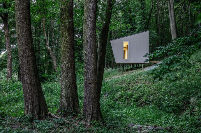 This tiny cabin floats above the forest’s sloping hills to preserve the natural landscape and preexisting trees!