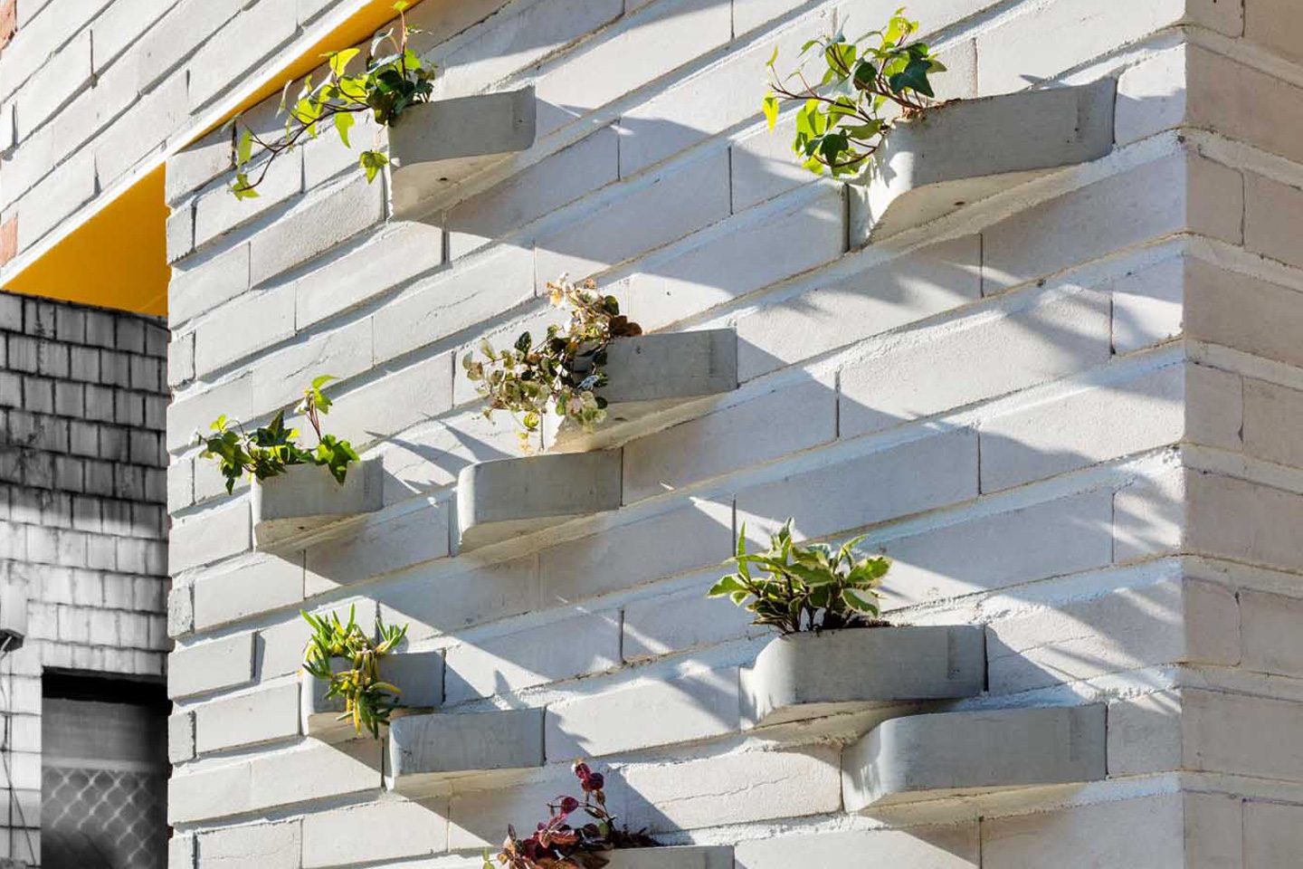 Creative brick design with a built-in planter turns the outer facade of this house into a vertical garden!