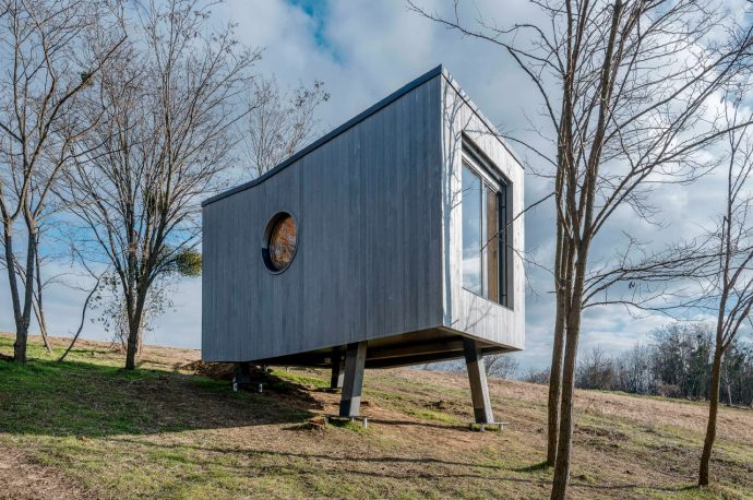 This tiny cabin rises above the ground on four stilts to mimic treehouses