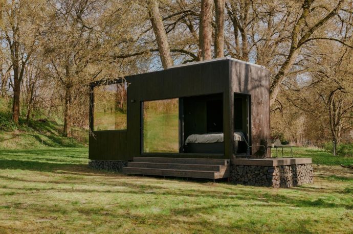 Small cabin with burnt wood design gives tranquility in the middle of nature