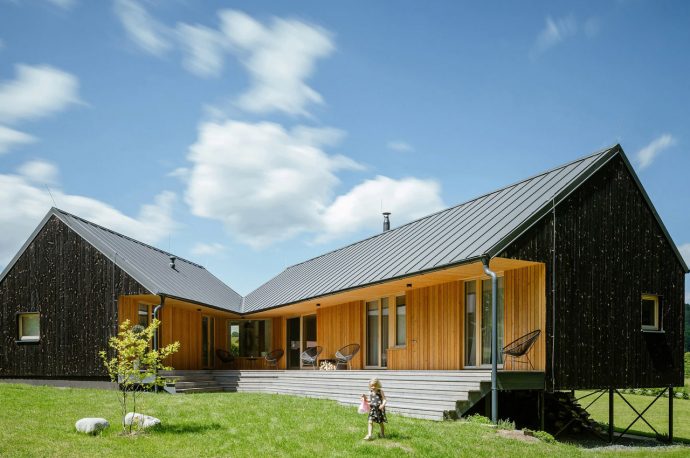 This V-shaped timber home in a Czech village features two elongated volumes intersecting each other