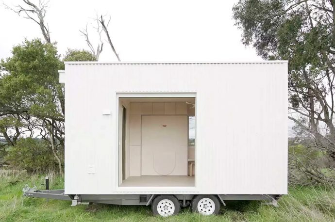 This all-white minimalist cabin is the flexible and functional tiny home on wheels you need
