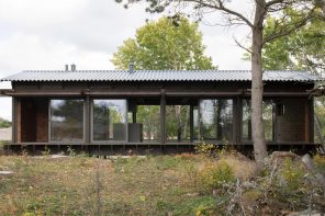 This tar-coated dark timber cabin in Sweden features an exposed structural grid