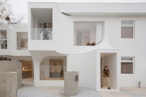 This rugged curved concrete hotel in China features an enclosed courtyard with sculptural partitions