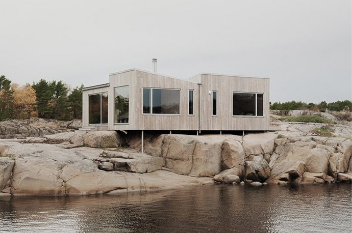 This wooden tiny cabin merges perfectly with the Norwegian archipelago it is located in
