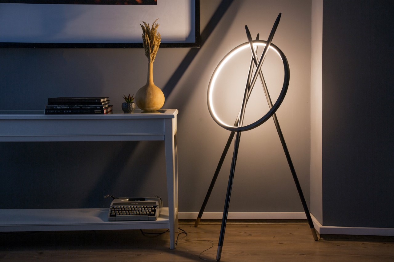 Minimalist floor lamp comes with a simple hoop elegantly resting on three sleek poles