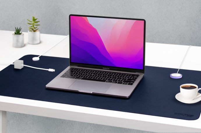 Faux leather desk mat keeps cables in order using magnets