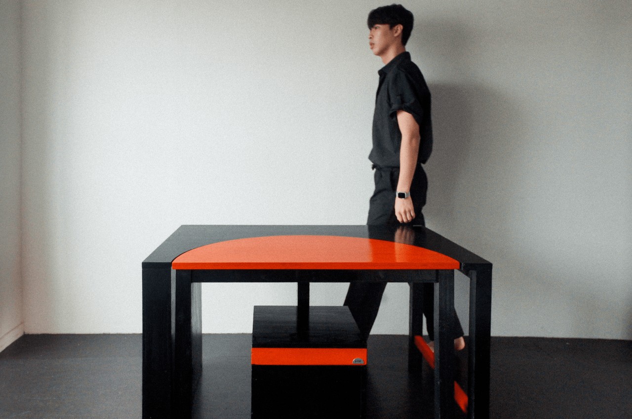 Modular table pivots to turn from work desk to dining table to social space