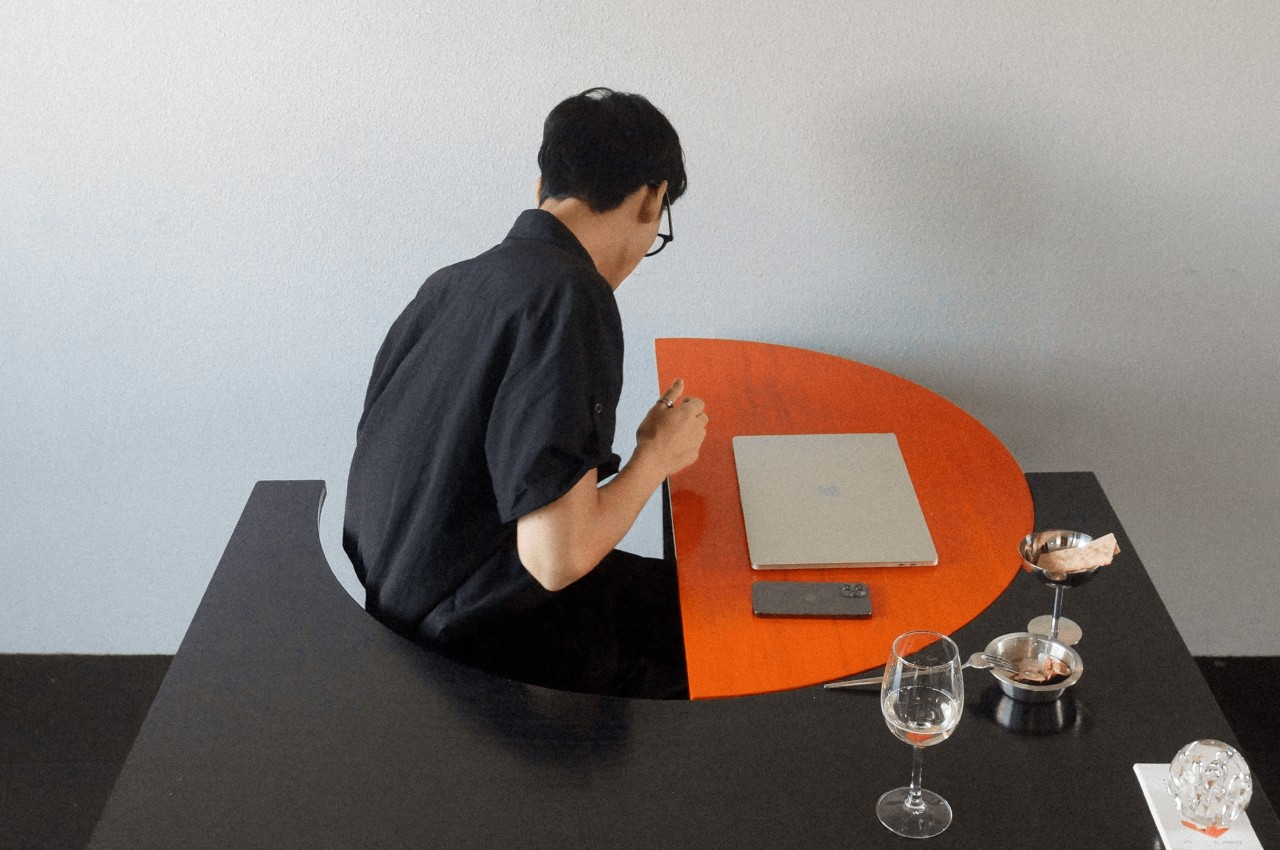 Modular table pivots to turn from work desk to dining table to social space