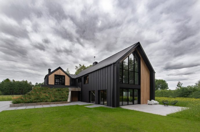 Contemporary wood and concrete home in Poland smartly conceals a garage under a hillside