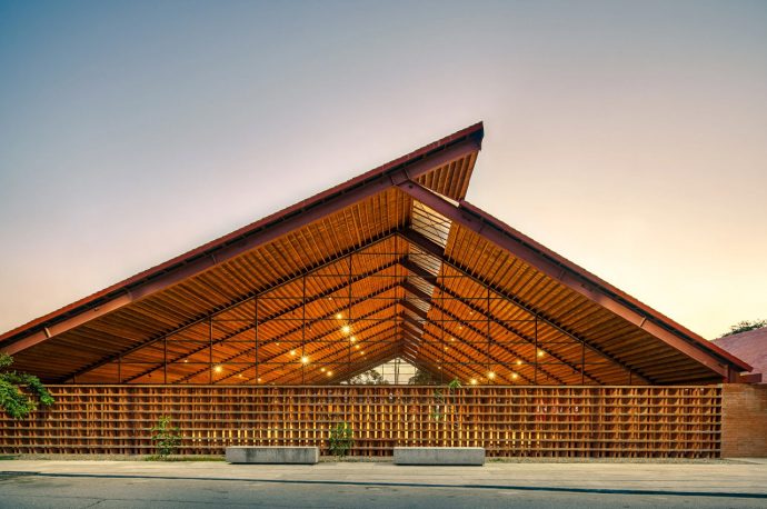 A brick music school in Mexico features a cantilevered roof made from locally sourced coconut wood