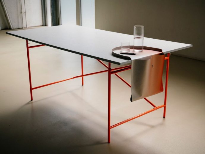 Paper saddlebag hangs over the edge to keep your desk organized