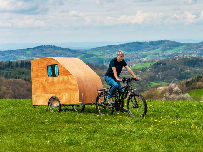 This e-bike-towed wooden trailer is designed for your solo weekend adventure