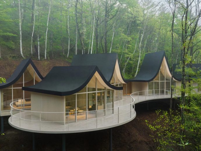 Nendo Designs Six Wooden Cottages Connected Via A Swooping Roof In Japan