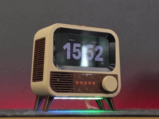 Retro tabletop radio with a large digital time display set to 15:52 and colorful LED underglow lights on a dark surface, mid-foreground view (informative image).