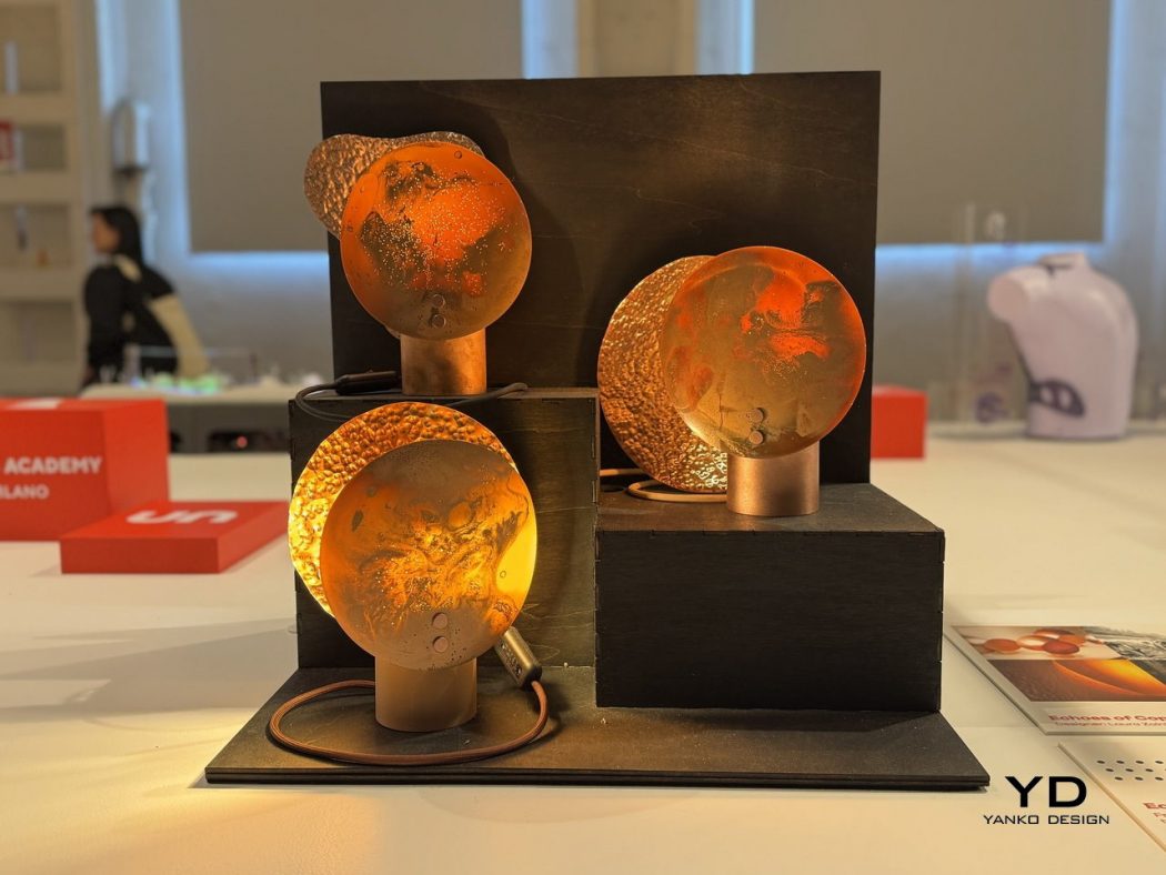 Copper-toned sculpture with four hammered circular disks mounted on copper posts on a black multi-level pedestal.