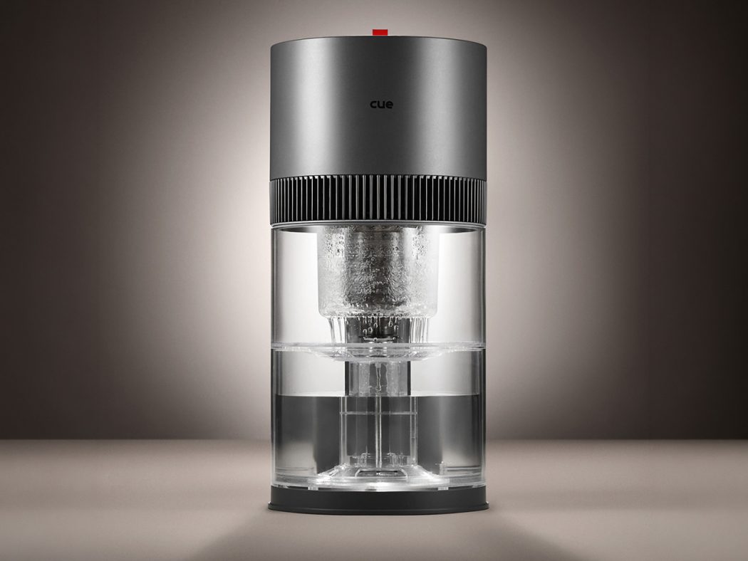 Sleek cylindrical coffee maker with a metallic top, ribbed band, and transparent glass water chamber.