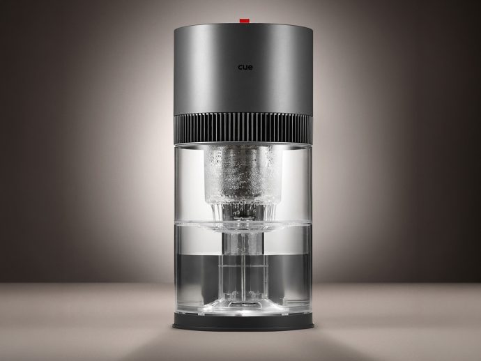 Sleek cylindrical coffee maker with a metallic top, ribbed band, and transparent glass water chamber.