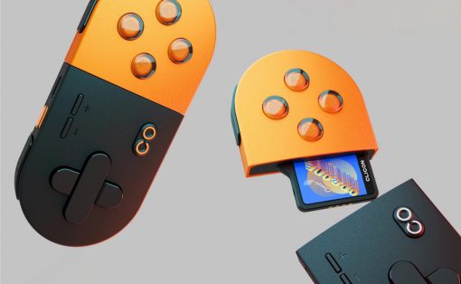 Two orange-and-black handheld game controllers with circular button layouts, one has a cartridge partially inserted in a slide-out slot.