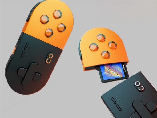 Two orange-and-black handheld game controllers with circular button layouts, one has a cartridge partially inserted in a slide-out slot.