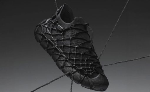 Black athletic shoe with a webbed, net-like lacing system suspended by cords on a gradient background