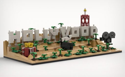 LEGO diorama spelling HELLO WORLD on a sandy desert base with palm trees and a red tower.
