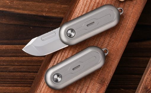 Two gray folding pocket knives on a wooden surface, one blade partially open.