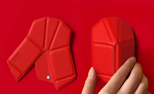 Two red geometric modular case pieces on a red background, with a hand snapping one piece into place.