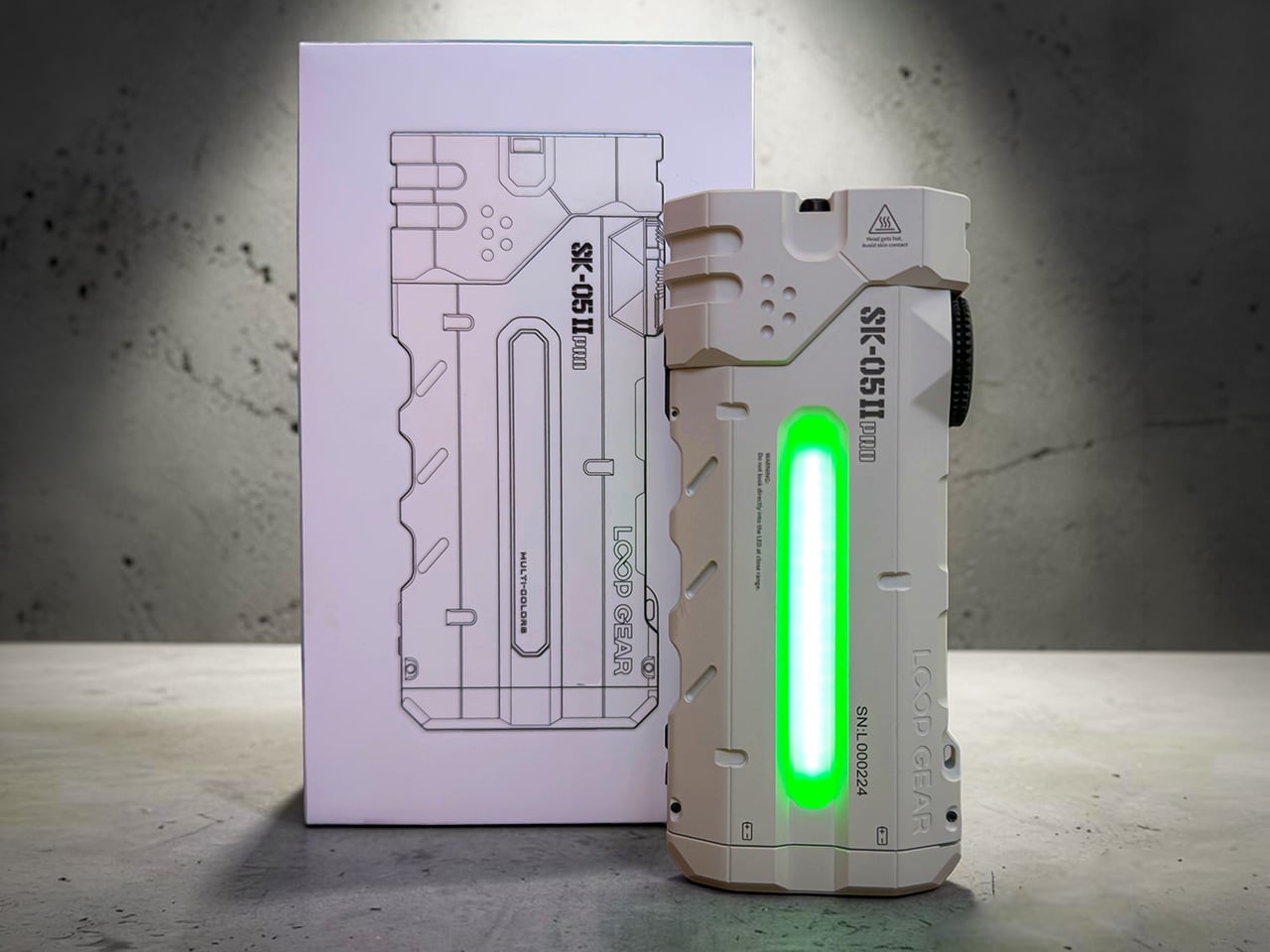 Rugged white handheld flashlight with a vertical green glow bar beside its blueprint-style box.