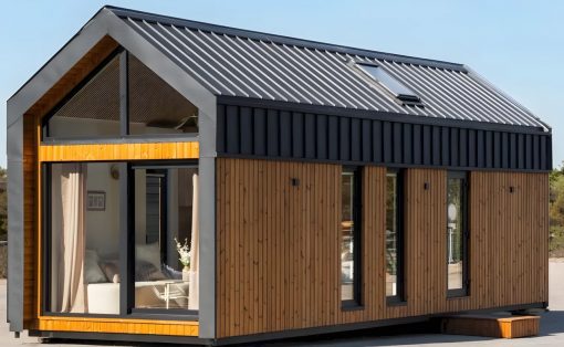 Modern tiny house with vertical wooden siding, a black metal roof, and a wide glass front window.