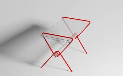 Modern red metal folding chair with clear acrylic seat and back, viewed from an angled side.