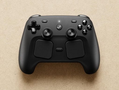 Black wireless game controller resting on a beige textured surface, featuring a D‑pad, two analog sticks, four face buttons (A, B, X, Y) and a center Steam button.