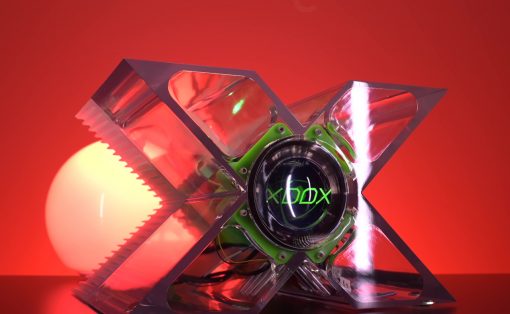 Futuristic X-shaped chrome device with a glowing green core displaying 'XDOX' against a red backdrop.