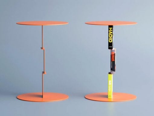 Two orange circular display stands; the left is empty, the right holds a vertical stack of books.