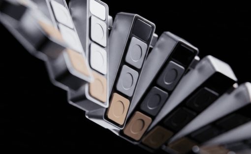 Close-up of a curved fan of color swatches in grayscale and warm beige tones against a black background.