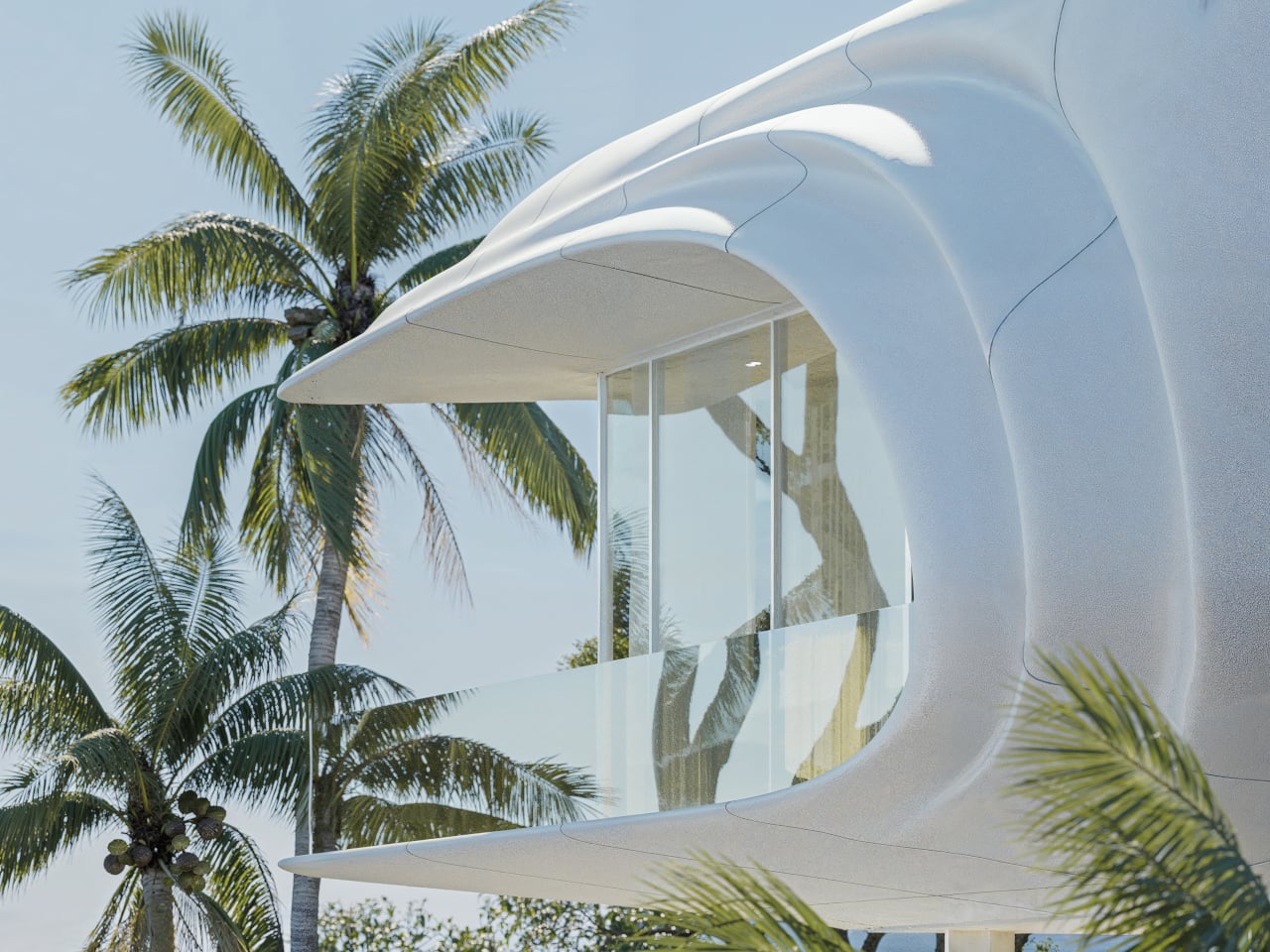 Futuristic white curved building with a glass balcony, set among tropical palm trees under a blue sky.