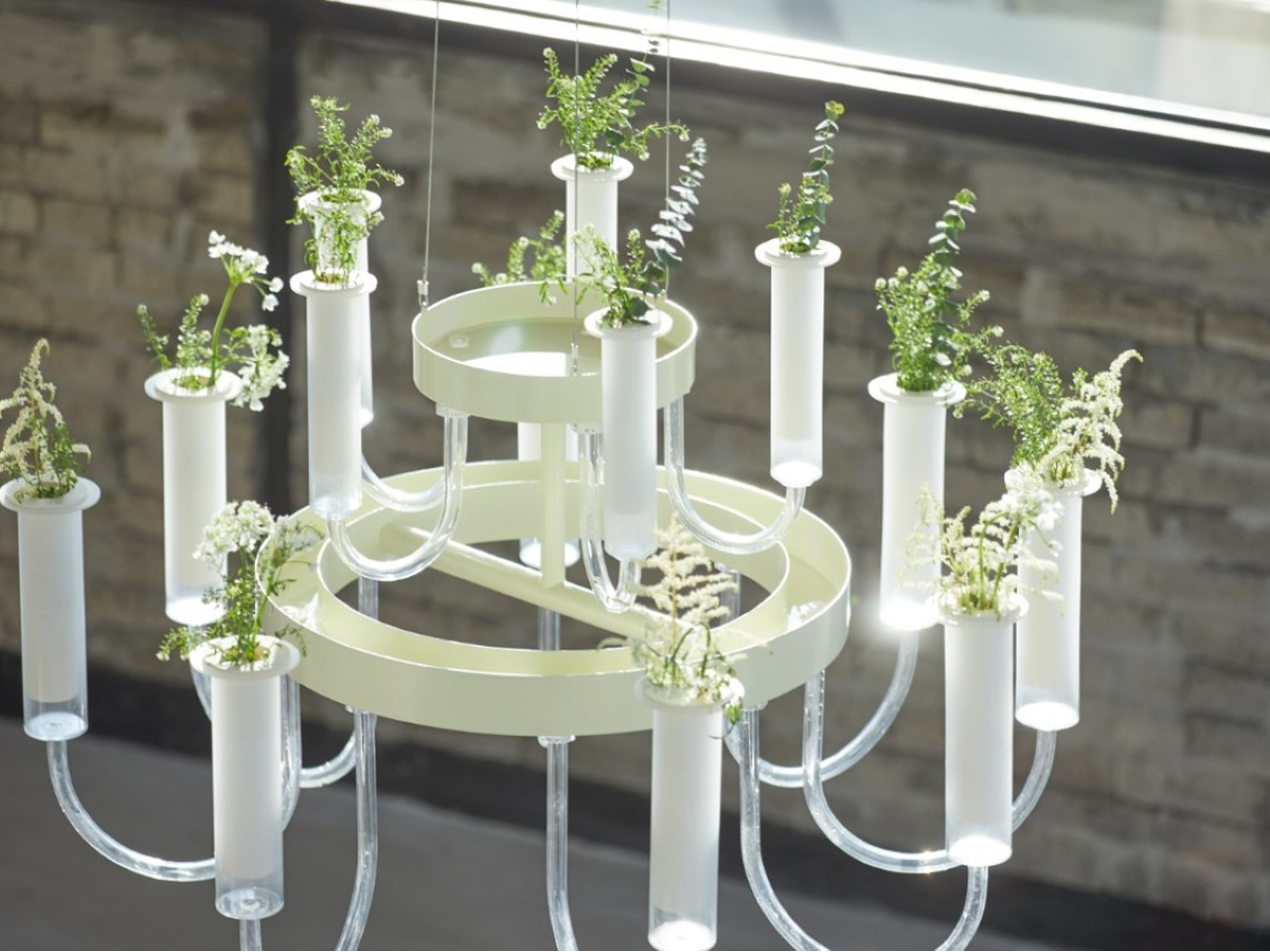 Modern chandelier with multiple glass tubes and small potted herbs attached for a decorative touch indoors.