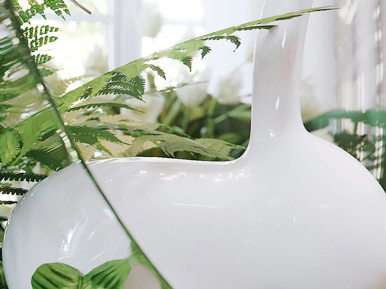 White glossy ceramic vase with a narrow neck among green ferns indoors.