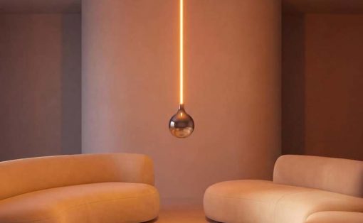 Minimalist lounge with rounded cream sofas and a warm, vertical pendant light centerpiece.