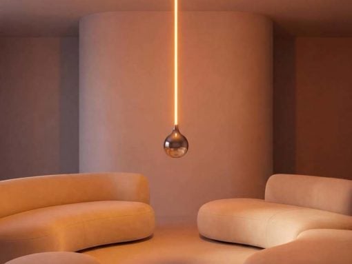 Minimalist lounge with rounded cream sofas and a warm, vertical pendant light centerpiece.