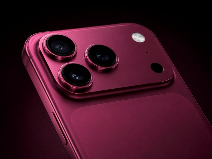 Close-up of a pink smartphone back featuring a triple-camera module and a small flash on a dark background, highlighting the lenses and metal rim.