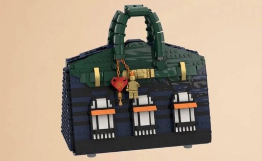 LEGO handbag built from dark blue and green bricks with a top handle and a red heart lock charm.