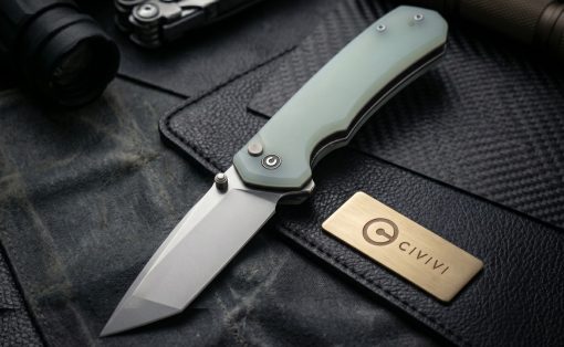Folding knife with a pale green handle and gray blade lying on dark leather, with a brass CIVIVI brand plate nearby.