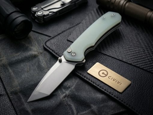 Folding knife with a pale green handle and gray blade lying on dark leather, with a brass CIVIVI brand plate nearby.